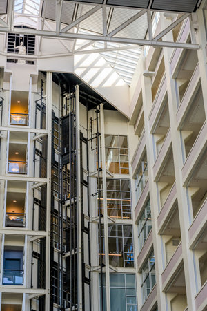The interior of a multifunctional multi-story building made of concrete and a glass roof through...
