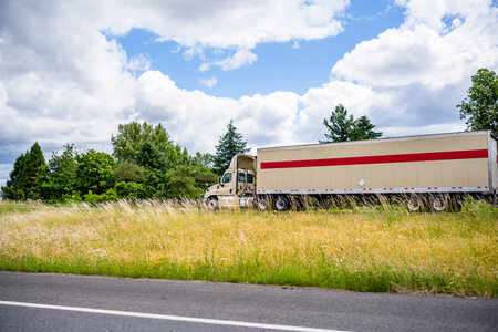 Classic beige powerful day cab diesel big rig semi truck with low cab and aerodynamic roof spoiler...