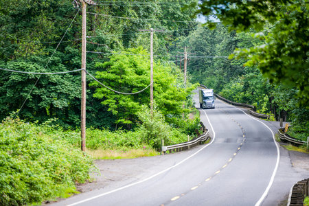 Gray bonnet big rig industrial semi truck transporting freight commercial cargo in refrigerator semi...