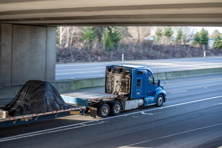 Classic big rig industrial blue semi truck tractor with low roof cab and sleeping compartment...