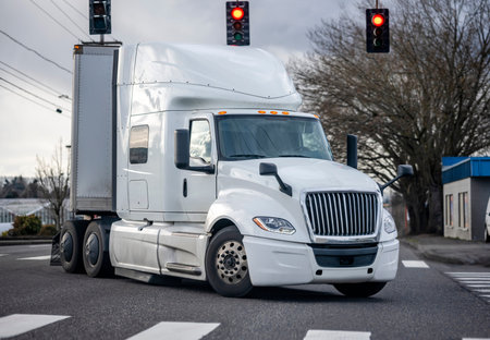Commercial big rig classic white industrial grade long haul professional semi truck transporting...