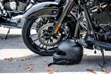 Black motorcycle safety helmet was left by a motorcyclist near the wheel of his black motorcycle...