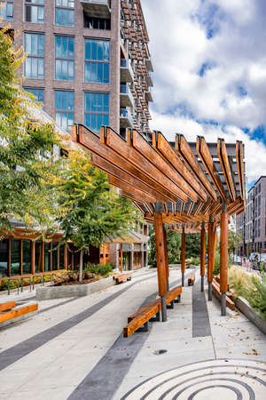 An impromptu outdoor gazebo with natural wood benches located on a city street with high-rise apartments and offices in the urban area of Portland invites any traveler or resident to relax and unwindの写真素材