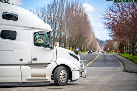 Classic white big rig industrial standard semi truck with dry van semi trailer transporting...