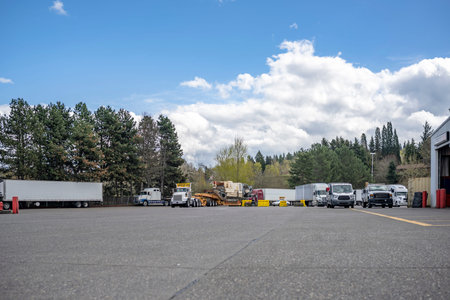 Industrial standard different bigs rigs semi trucks tractors with loaded semi trailers standing for...