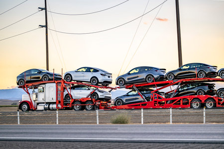 Industrial grade popular big rig white car hauler semi truck tractor transporting fastened cars on...