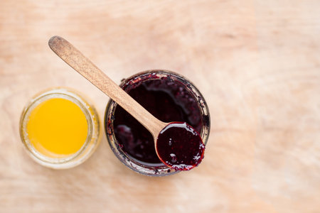 jar of jam and honey on wooden background