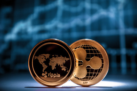 Two golden xrp ripple coins with financial charts on background. Cryptocurrency business conの写真素材