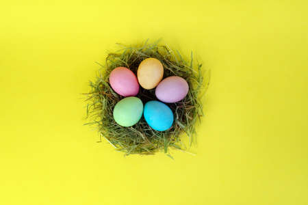 pastel colored eggs in nest easr bunny and the inscription of the cubes happy Easterの写真素材