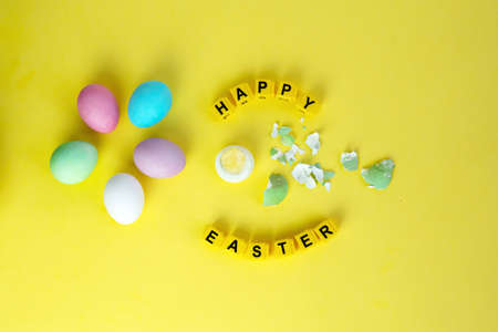 pastel colored eggs in nest easr bunny and the inscription of the cubes happy Easterの写真素材