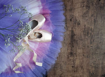 point shoes with color shirts on wooden floor Ballet shoes and ribbons, beige colors. Pointe shoes on the floor, close-up. ballet background.の写真素材