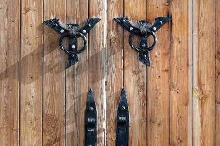 Brown wooden gate with forged metal handlesの写真素材