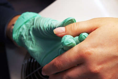 the work of a manicure master: processing nails with a file before applying gel polishの写真素材
