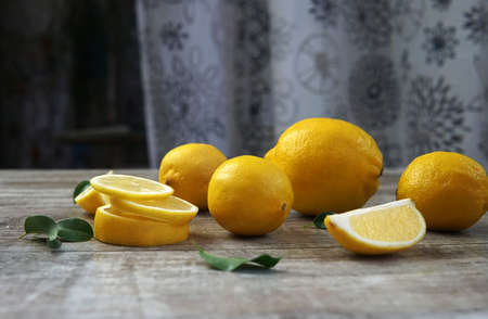 Fresh lemons and lemons leaves on rustic wooden background. Fresh lemons and lemon slice on wooden table with flat lay.の写真素材