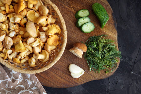 mushrooms chanterelles in a basket cucumbers on the table on a dark background dish