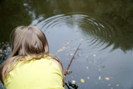 girl fishing holding a fishing rodの写真素材