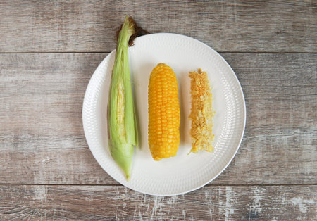 three states of corn on plate. cop. raw and eaten isolate