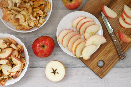 three apples and three plates with dry apples and slice apples on the table and knife
