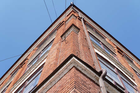 the corner of the house is made of red brick windows the blue skyの写真素材