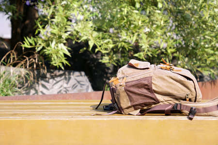 forgotten brown bag on a bench against the background of trees.の写真素材