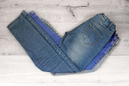 jeans for children are on the table of different colorsの写真素材