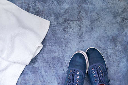 Flat lay of blue sneaker, whitetowel sport bra. sport equipments, fitness items, top view. blue backgroundの写真素材