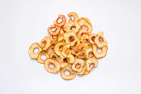 dried apples are poured into rings from a bag on a wooden table. Close upの写真素材