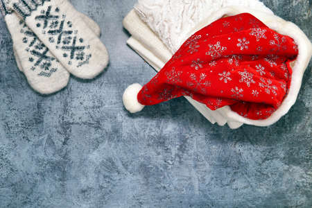 santa hat, mittens and scarf lie on a blue backgroundの写真素材