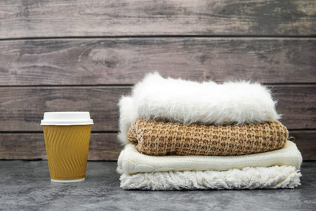 winter clothes. Sweater, scarf hat. A glass of coffee.