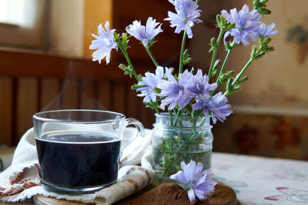 healing drinks. chicory drink. cup of chicory drink and flowers on tableの写真素材