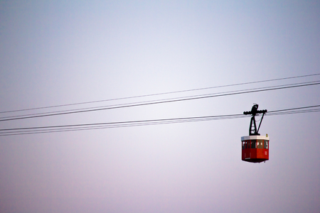Red cabin of cableway stands out on Barcelona's portの写真素材