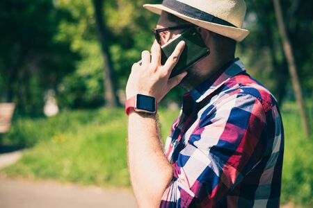 BUCHAREST, ROMANIA, - October 26, 2017: Person using smart watch and a smartphone walking on the park in a sunday. Young man making gestures on a wearable smart watch. Illustrative editorial content.のeditorial素材