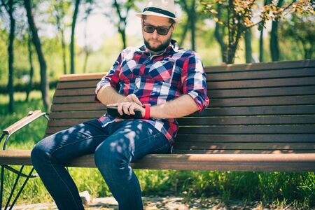 BUCHAREST, ROMANIA, - October 26, 2017: Person using smart watch and a smartphone walking on the park in a sunday. Young man making gestures on a wearable smart watch. Illustrative editorial content.のeditorial素材