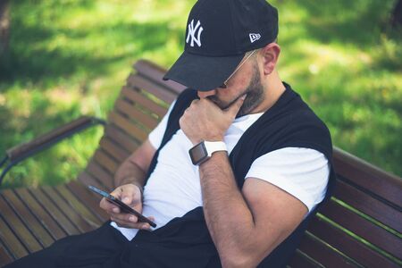 BUCHAREST, ROMANIA, - October 26, 2017: Person using smart watch and a smartphone walking on the park in a sunday. Young man making gestures on a wearable smart watch. Illustrative editorial content.のeditorial素材