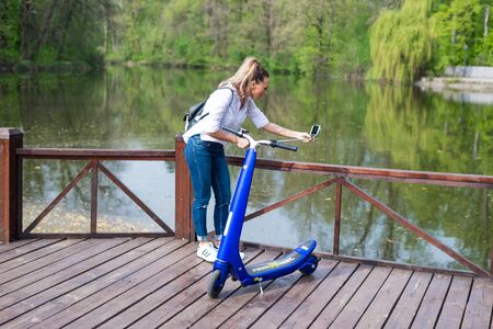BUCHAREST, ROMANIA, - October 26, 2017: Woman using electric scooter in the park on a sunny day. Illustrative editorial content.のeditorial素材