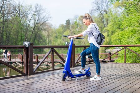 BUCHAREST, ROMANIA, - October 26, 2017: Woman using electric scooter in the park on a sunny day. Illustrative editorial content.のeditorial素材