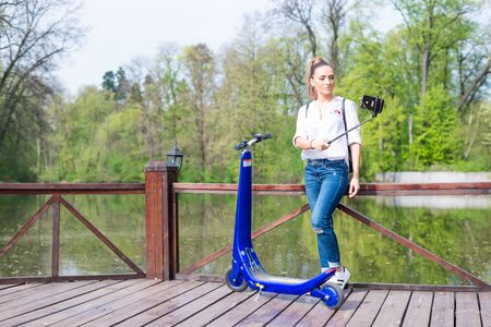 BUCHAREST, ROMANIA, - October 26, 2017: Woman using electric scooter in the park on a sunny day. Illustrative editorial content.のeditorial素材