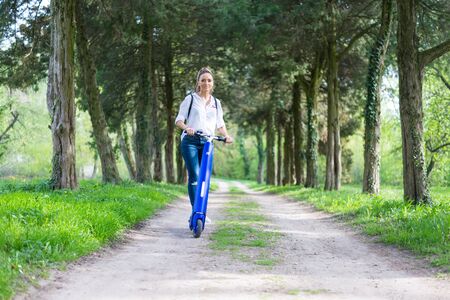 BUCHAREST, ROMANIA, - October 26, 2017: Woman using electric scooter in the park on a sunny day. Illustrative editorial content.のeditorial素材