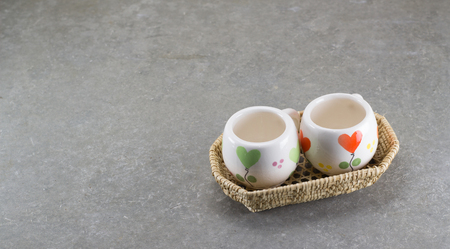 Small same cups in weave basket on loft style tableの写真素材