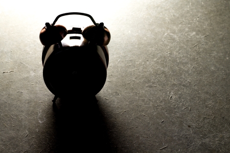 Dark of old Alarm Clock on loft cement floor.の写真素材
