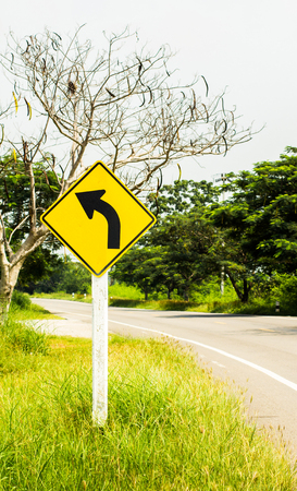 Traffic Signs turn left beside road country.の写真素材