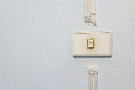 Old white switch on the wall of houseの写真素材