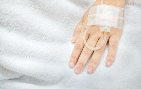 Saline intravenous drip in a asia woman patient hand. IV drip in hand. by high angle shots view.の写真素材