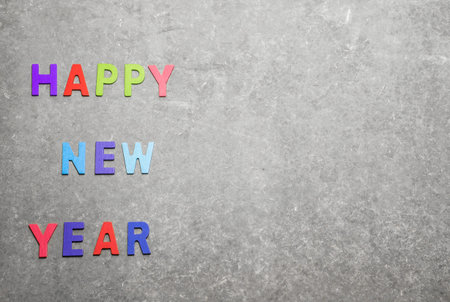 happy new year colorful wording by color wooden on gray  background and space for fill any text.の写真素材