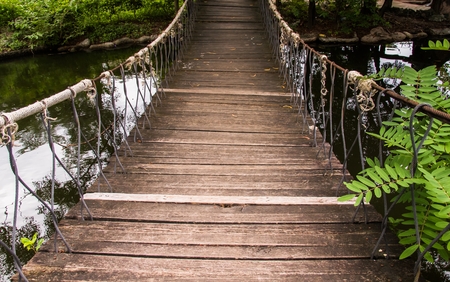 Old wooden bridge stretching across natural streams in afternoon.の写真素材