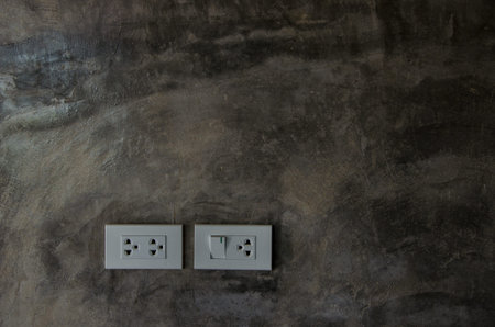 outlet electric plug on black wall.