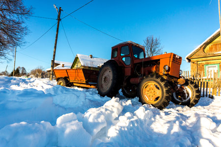 Lyashki, Russia - February 23, 2018: Old tractor removes snow in winter on the street of a...