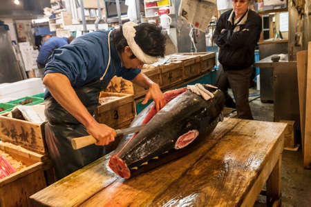 Tokyo, Japan - January 15, 2010: Early morning at Fish Market. Vendor cutting tuna at Tsukiji Fish Market.のeditorial素材