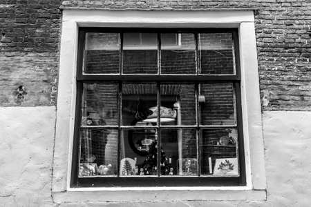Amsterdam, The Netherlands - December 11, 2009: Reflections in old fashioned traditional window in Amsterdam. Black and white imageのeditorial素材