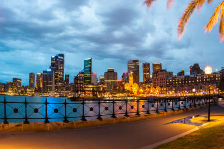 Sydney, Australia - January 11, 2009: Night View of Sydney Promenade. Skyscrapers are seen across the water of Sydney Harbor.のeditorial素材